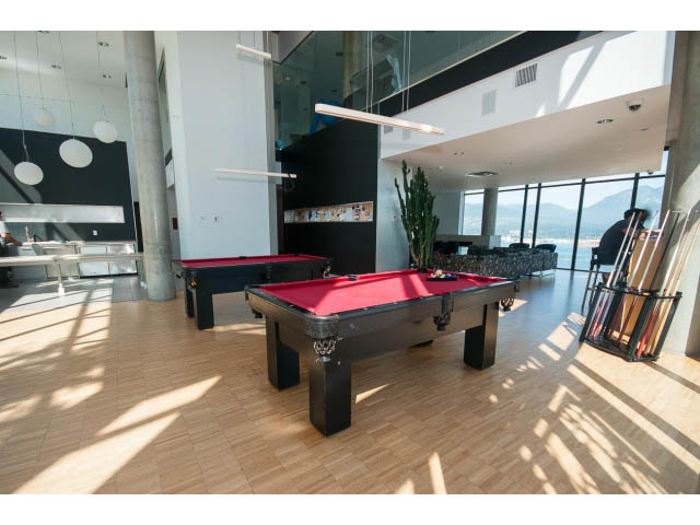 Spacious living room with hardwood floors, city view, and a pool table. - 803 - 128 Cordova St W, Vancouver Downtown