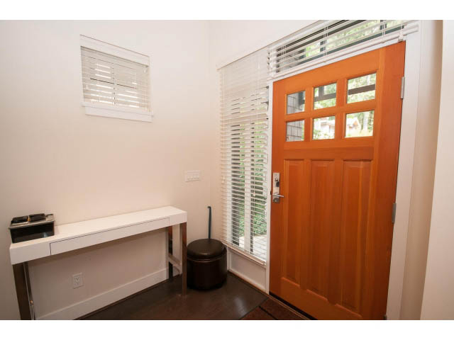Foyer with wooden door, small ottoman, and white countertop. - 26 - 555 Raven Woods Drive, North Vancouver