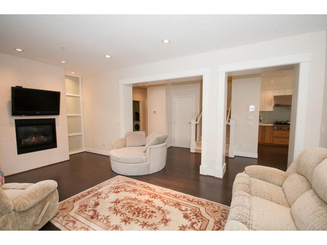 Spacious living room with hardwood floors and a large area rug. - 26 - 555 Raven Woods Drive, North Vancouver