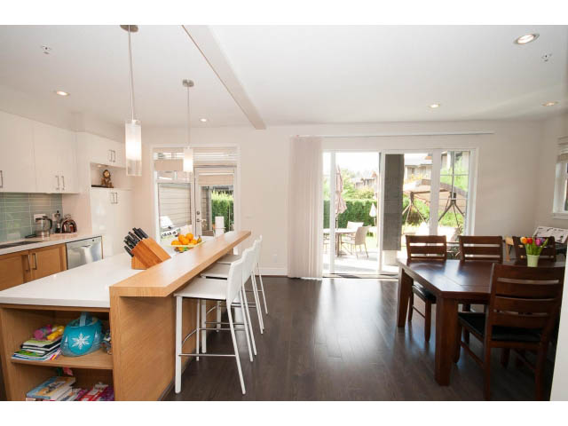 Bright kitchen with white countertops, hardwood floors, and a city view. - 26 - 555 Raven Woods Drive, North Vancouver