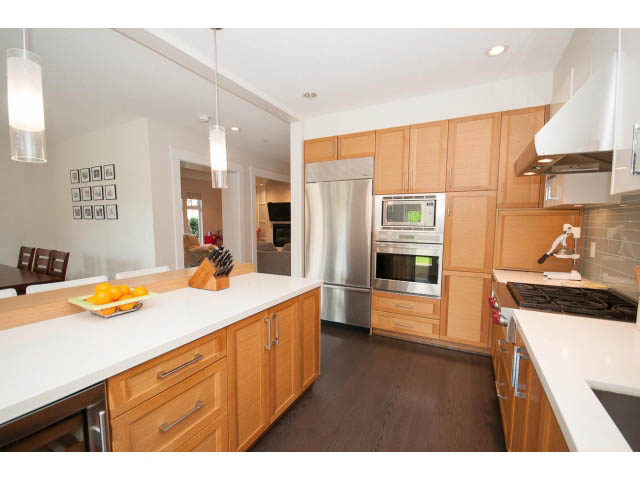 Bright kitchen with white countertops, stainless steel appliances, and hardwood floors. - 26 - 555 Raven Woods Drive, North Vancouver