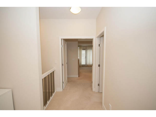Spacious hallway leading to bedrooms, carpeted floors, neutral walls. - 26 - 555 Raven Woods Drive, North Vancouver