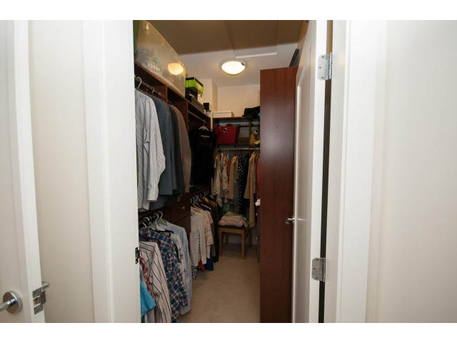 Spacious walk-in closet with neatly arranged clothing and storage. - 26 - 555 Raven Woods Drive, North Vancouver