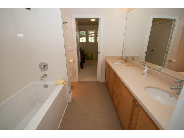 Bright bathroom with light wood cabinets and beige countertops. - 26 - 555 Raven Woods Drive, North Vancouver