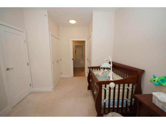 Bright nursery with wooden cribs, soft carpet, and white walls. - 26 - 555 Raven Woods Drive, North Vancouver