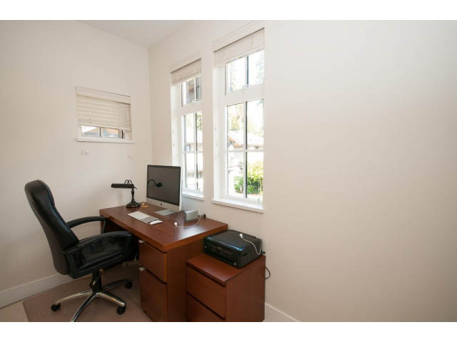 Bright office with wooden desk, black office chair, and large windows. - 26 - 555 Raven Woods Drive, North Vancouver