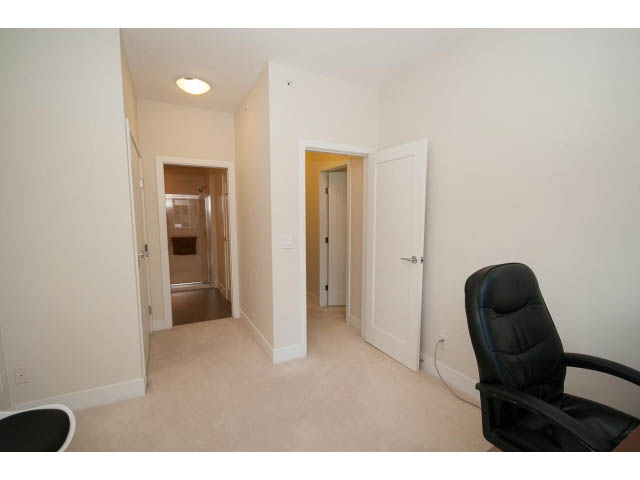 Bright living room with white walls, black leather chairs, and carpeted floors. - 26 - 555 Raven Woods Drive, North Vancouver