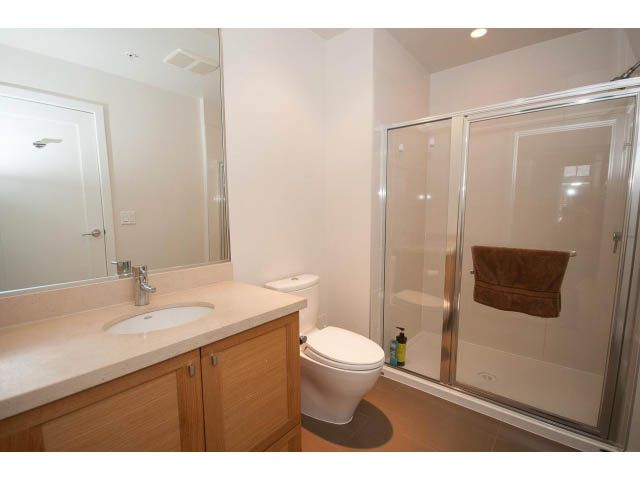 Spacious bathroom with dual sinks, large mirror, and walk-in shower. - 26 - 555 Raven Woods Drive, North Vancouver