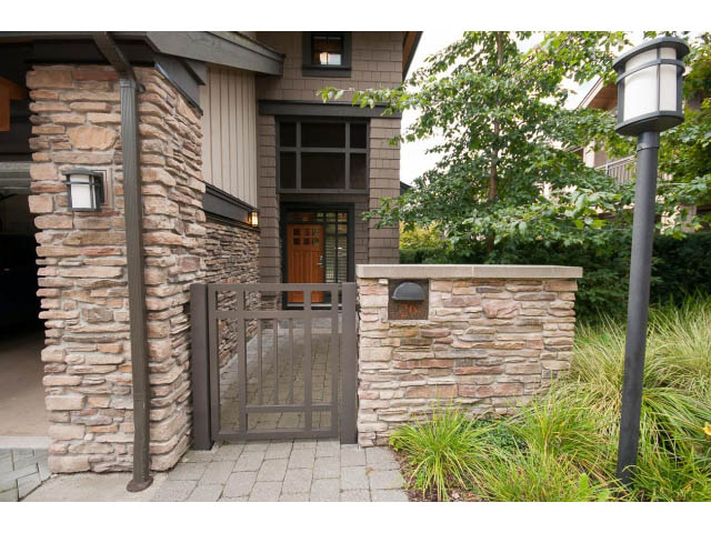 Furnished living room with stone accents and modern lighting. - 26 - 555 Raven Woods Drive, North Vancouver