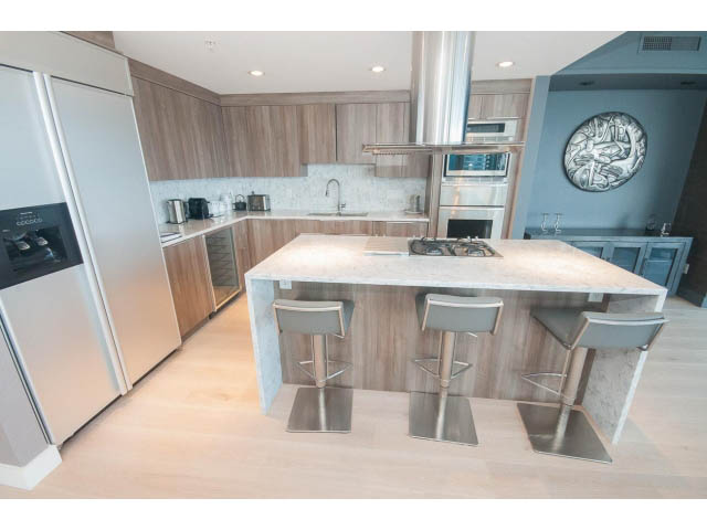 Bright kitchen with modern appliances, light wood cabinets, and a breakfast bar with stools. - 1702 - 1281 W. Cordova Street, Vancouver Downtown