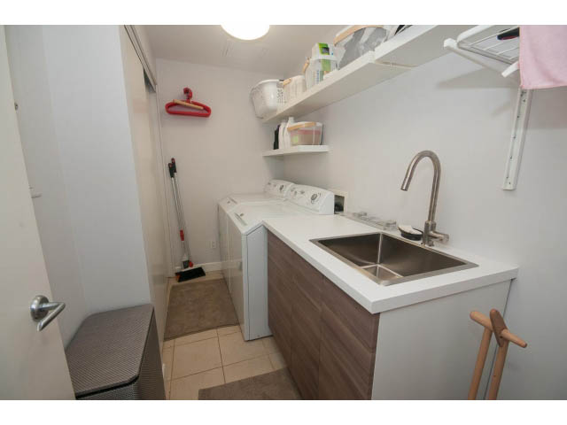 Bright kitchen with white countertops, wooden cabinets, and a stainless steel sink. - 1702 - 1281 W. Cordova Street, Vancouver Downtown