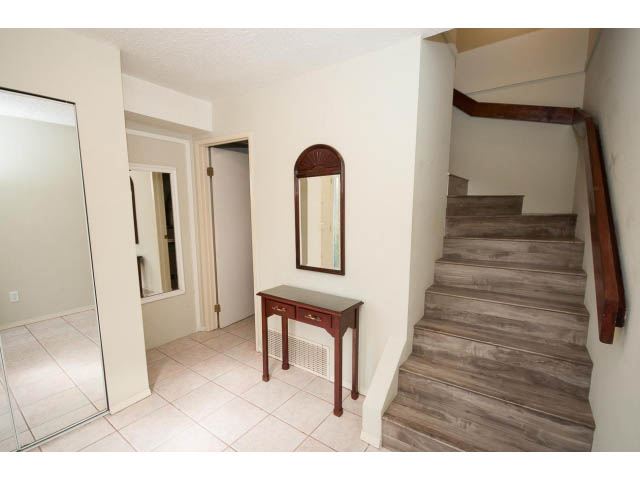 Foyer with wooden staircase and mirrored closet doors. - 1730 Bowser Ave., North Vancouver