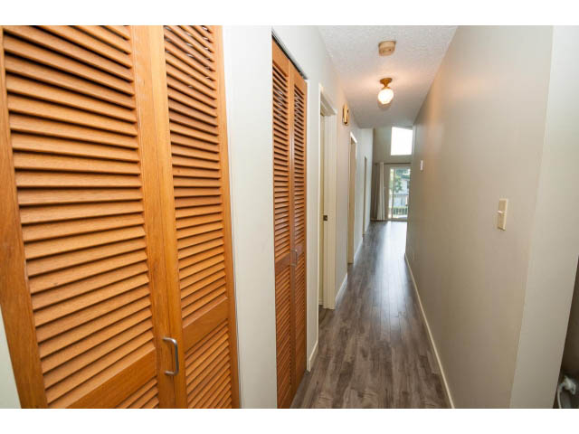 Furnished hallway with wooden louvered doors and hardwood floors. - 1730 Bowser Ave., North Vancouver