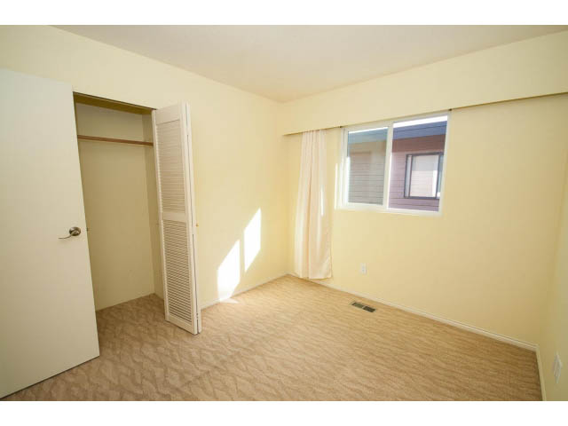 Bright living room with sliding glass doors and carpeted floor. - 1730 Bowser Ave., North Vancouver
