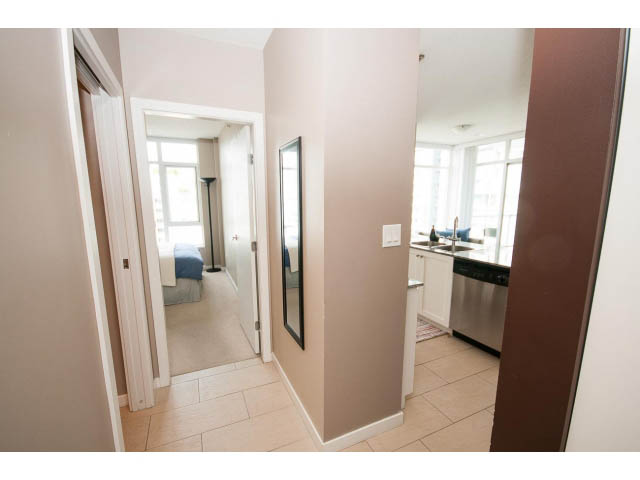 Bright kitchen with tiled floor and modern appliances, leading to a cozy bedroom with a window view. - 1202 - 480 Robson Street, Vancouver Downtown