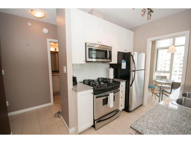 Bright kitchen with stainless steel appliances, granite countertops, and city view. - 1202 - 480 Robson Street, Vancouver Downtown