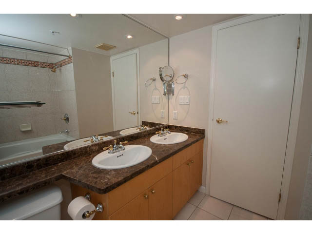 Bright bathroom with marble countertops and a large mirror. - 707 - 1288 Marinaside Crescent, Vancouver Downtown