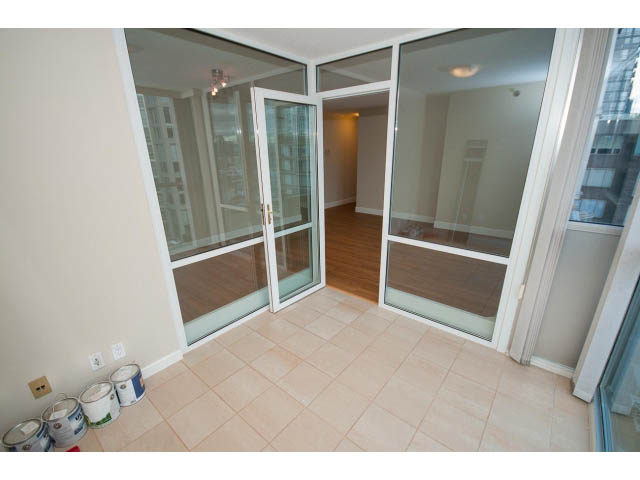 Bright living room with large glass doors, city view, and tiled floor. - 707 - 1288 Marinaside Crescent, Vancouver Downtown