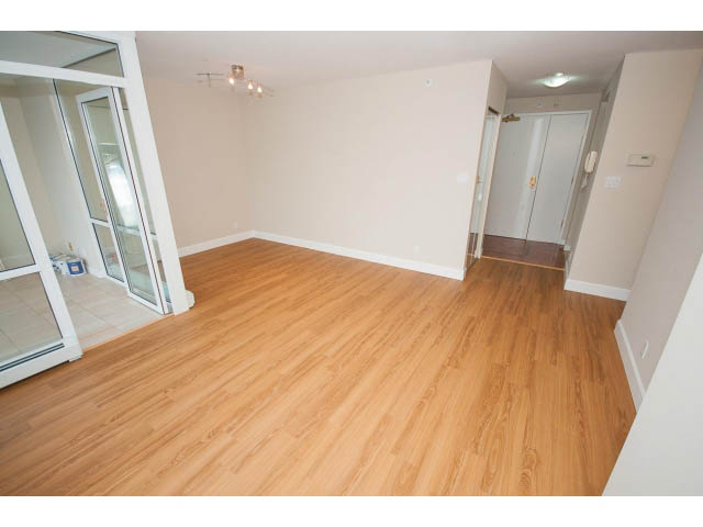 Bright living room with hardwood floors and sliding glass door leading to balcony. - 707 - 1288 Marinaside Crescent, Vancouver Downtown