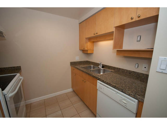 Bright kitchen with granite countertops and wooden cabinets, clean and ready for move-in. - 707 - 1288 Marinaside Crescent, Vancouver Downtown