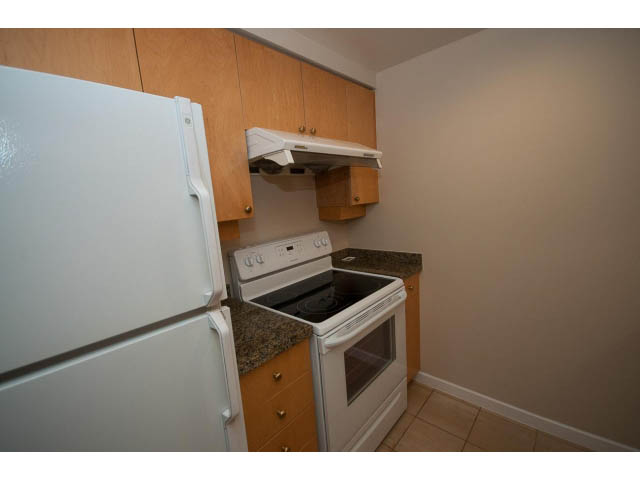 Bright kitchen with granite countertops and light wood cabinets. - 707 - 1288 Marinaside Crescent, Vancouver Downtown
