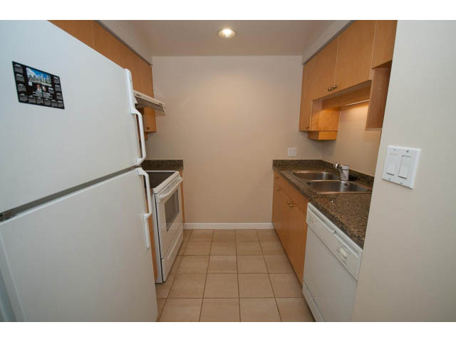 Bright kitchen with granite countertops and white appliances, clean and modern. - 707 - 1288 Marinaside Crescent, Vancouver Downtown