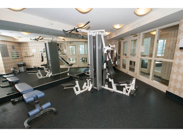 Furnished gym with various exercise equipment and mirrors. - 707 - 1288 Marinaside Crescent, Vancouver Downtown