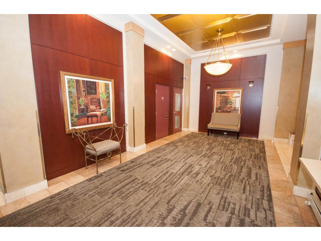 Furnished living room with wooden paneling, artwork, and a chandelier. - 707 - 1288 Marinaside Crescent, Vancouver Downtown