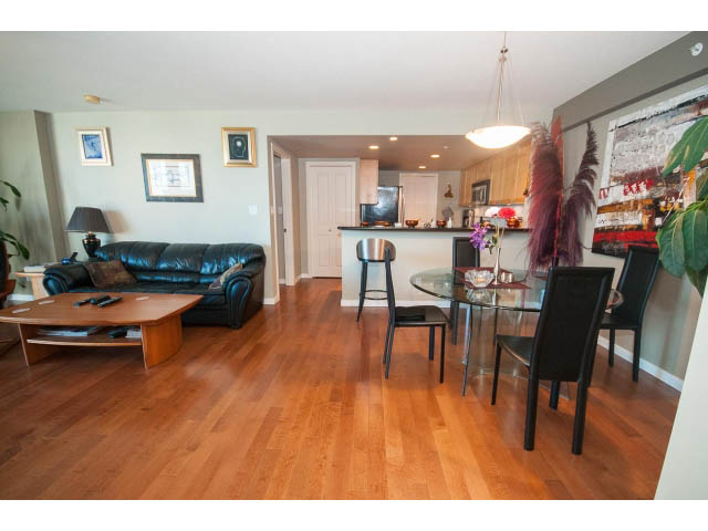 Furnished living room with hardwood floors and a cozy black leather couch. - 603 - 1425 West 6th Ave, Vancouver West Side