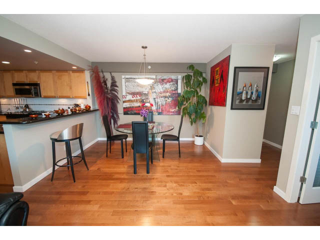 Furnished kitchen with hardwood floors, modern decor, and a view of the city. - 603 - 1425 West 6th Ave, Vancouver West Side