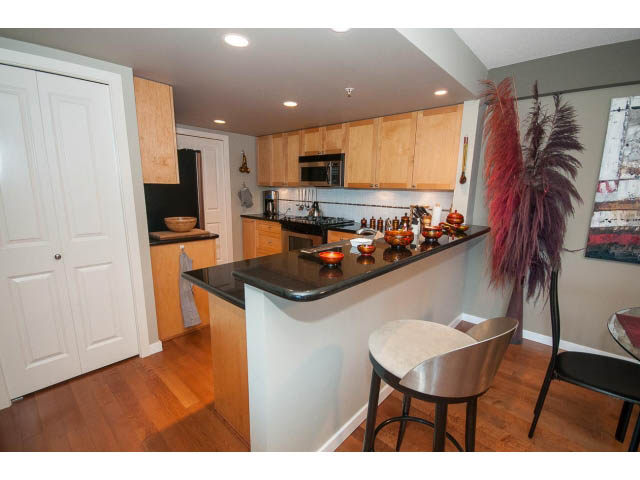 Bright kitchen with wooden cabinets, granite countertops, and hardwood floors. - 603 - 1425 West 6th Ave, Vancouver West Side