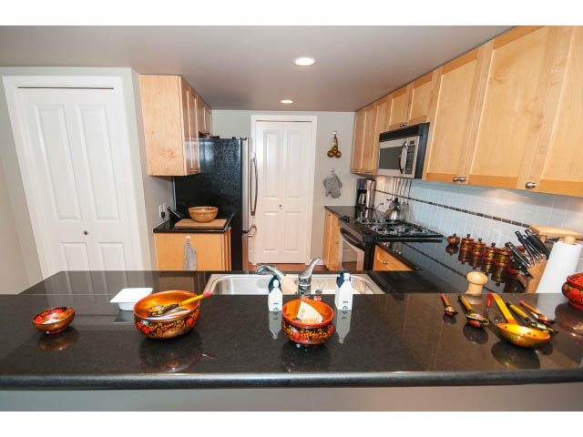 Bright kitchen with black granite countertops and wooden cabinets. - 603 - 1425 West 6th Ave, Vancouver West Side