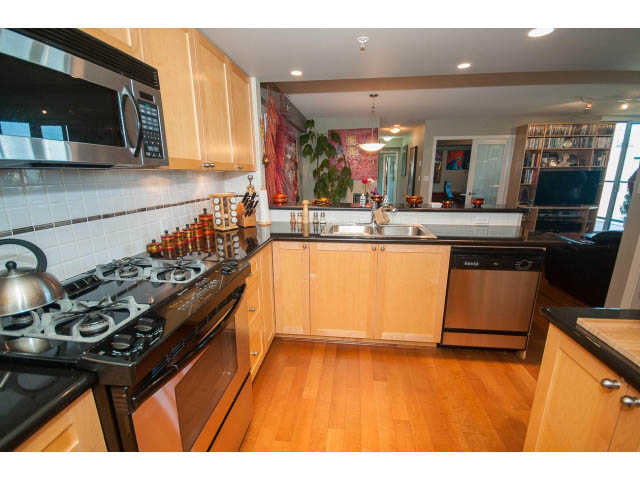 Bright kitchen with wooden floors, black countertops, and a city view. - 603 - 1425 West 6th Ave, Vancouver West Side