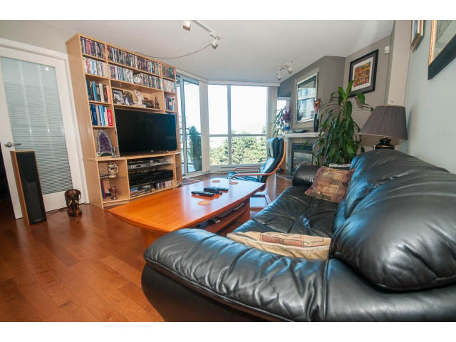 Furnished living room with hardwood floors, city view, and a large TV. - 603 - 1425 West 6th Ave, Vancouver West Side