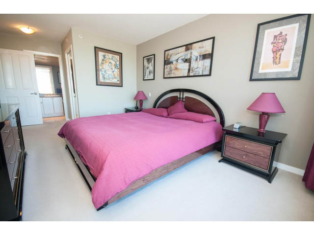 Furnished bedroom with pink bedding, black headboard, and framed artwork on walls. - 603 - 1425 West 6th Ave, Vancouver West Side