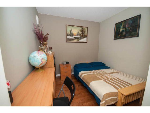 Bright bedroom with wooden floors, desk, and two twin beds, neatly arranged. - 603 - 1425 West 6th Ave, Vancouver West Side