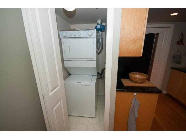 Bright laundry room with white cabinets, countertop, and hardwood floors. - 603 - 1425 West 6th Ave, Vancouver West Side