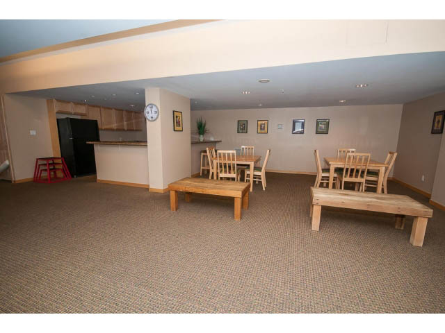 Furnished dining area with wooden tables and chairs, carpeted floor, and wall art. - 603 - 1425 West 6th Ave, Vancouver West Side