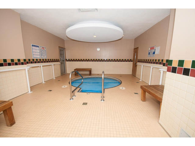 Spacious indoor pool area with tiled walls and floor, benches, and safety railings. - 603 - 1425 West 6th Ave, Vancouver West Side