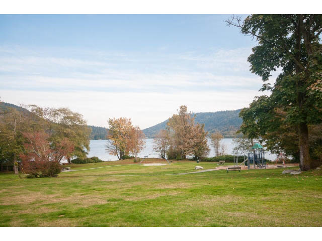 Spacious living room with a stunning view of the lake and mountains. - 389 Beachview Dr, North Vancouver