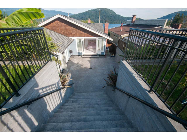 Bright patio with steps leading to a cozy, furnished patio area. - 389 Beachview Dr, North Vancouver