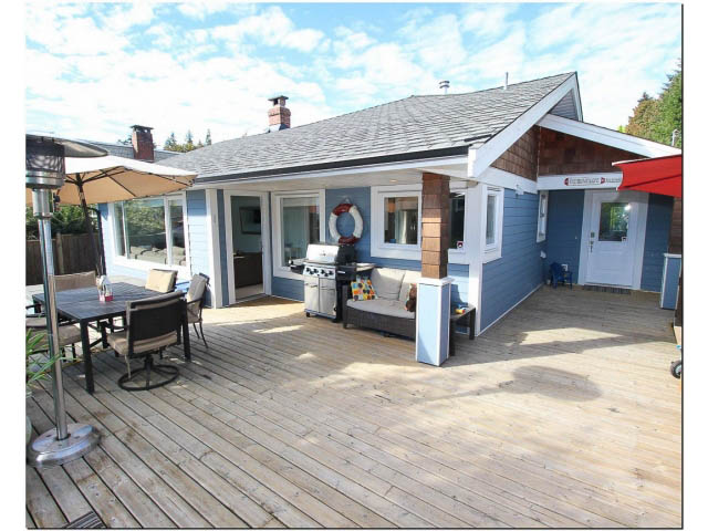 Furnished living room with wooden deck and outdoor dining area. - 389 Beachview Dr, North Vancouver