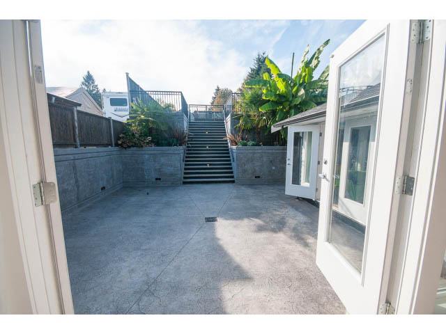 Bright patio with concrete flooring and steps leading up to a garden area. - 389 Beachview Dr, North Vancouver