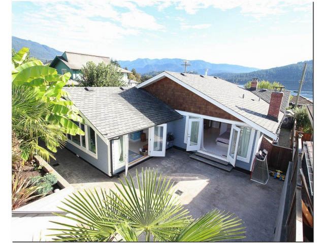 Bright living room with large windows, city view, and modern furnishings. - 389 Beachview Dr, North Vancouver