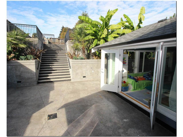 Furnished living room with concrete floors and outdoor stairs leading to a garden. - 389 Beachview Dr, North Vancouver