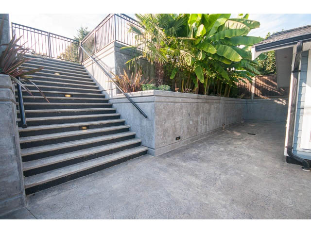 Staircase leading to a private patio with lush greenery. - 389 Beachview Dr, North Vancouver
