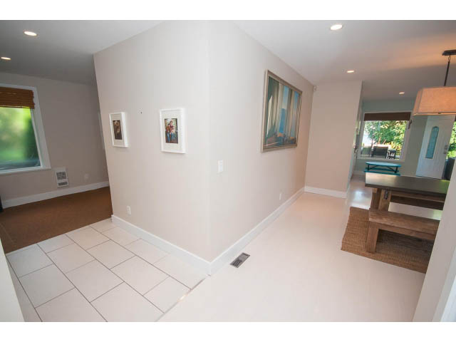 Bright living room with white tile flooring and framed artwork on the wall. - 389 Beachview Dr, North Vancouver
