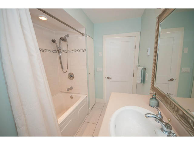 Bright bathroom with white sink, light blue walls, and a shower with a glass door. - 389 Beachview Dr, North Vancouver