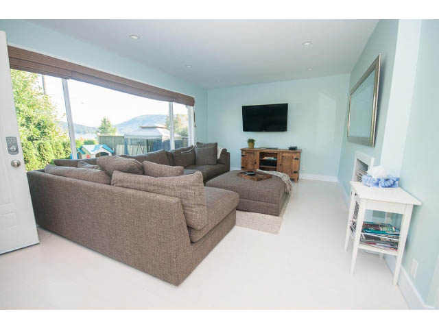 Bright living room with large sectional sofa, city view, and modern decor. - 389 Beachview Dr, North Vancouver