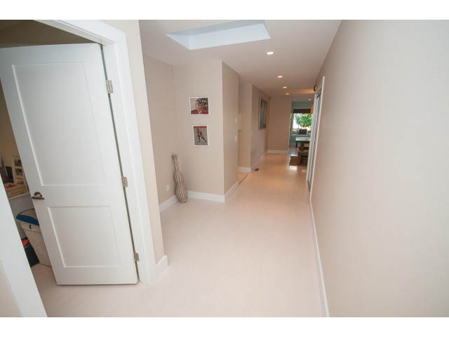 Bright hallway with white doors and framed artwork on the walls. - 389 Beachview Dr, North Vancouver